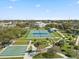 Aerial view showcases tennis and shuffleboard courts, walking paths, and lush landscaping in a vibrant community setting at 2401 Ecuadorian Way # 45, Clearwater, FL 33763