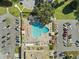 Overhead view of a community pool surrounded by seating, lush landscaping, and parking at 2401 Ecuadorian Way # 45, Clearwater, FL 33763