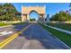 Community entrance showcasing a decorative stone archway over a road with double yellow lines at 2401 Ecuadorian Way # 45, Clearwater, FL 33763
