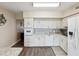 Bright kitchen featuring white cabinetry, modern appliances, and laminate wood flooring at 2401 Ecuadorian Way # 45, Clearwater, FL 33763