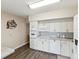 Kitchen with white cabinetry, modern appliances, laminate wood flooring, and neutral walls at 2401 Ecuadorian Way # 45, Clearwater, FL 33763