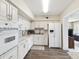 Well-lit kitchen featuring white cabinetry, modern appliances, and laminate wood flooring at 2401 Ecuadorian Way # 45, Clearwater, FL 33763