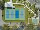 Aerial view of well-maintained tennis courts, shuffleboard, and manicured common areas with mature trees at 2401 Ecuadorian Way # 45, Clearwater, FL 33763