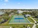 Aerial view of community tennis courts; well-maintained with blue surface and surrounded by lush green landscape at 2401 Ecuadorian Way # 45, Clearwater, FL 33763