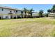Expansive grassy backyard with multi-Gathering homes under clear blue skies and palm trees at 4510 Limerick Dr, Tampa, FL 33610