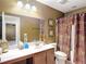 Cozy bathroom with decorative elements on the counter and a shower with curtain in earth tones at 4510 Limerick Dr, Tampa, FL 33610