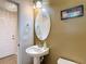 Bathroom with pedestal sink, oval mirror, and decorative lighting at 4510 Limerick Dr, Tampa, FL 33610