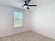 Bright bedroom features a window, neutral carpet, and a modern ceiling fan at 4510 Limerick Dr, Tampa, FL 33610