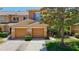 Well-kept townhome with a two-car garage and mature trees in a manicured yard at 4510 Limerick Dr, Tampa, FL 33610