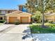 Welcoming townhome exterior showcasing a lush green lawn, well-placed trees, and private garages, offering a cozy curb appeal at 4510 Limerick Dr, Tampa, FL 33610