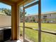 Screened patio showcasing a community lawn and neighboring townhomes under a clear blue sky at 4510 Limerick Dr, Tampa, FL 33610