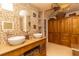 Bathroom featuring dual vessel sinks, mosaic-tiled wall, and stylish storage cabinets at 1928 Cove Pointe Drive, Venice, FL 34293
