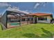 A spacious screened lanai provides outdoor living space with access to a pool and beautiful yard at 1928 Cove Pointe Drive, Venice, FL 34293
