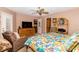 Main bedroom with a tropical-themed bedspread, ceiling fan, and doorway to another room at 1928 Cove Pointe Drive, Venice, FL 34293