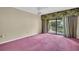Bright bedroom with sliding glass doors to balcony, neutral wall paint and ceiling fan at 1001 Old Mill Pond Rd, Palm Harbor, FL 34683