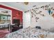 Charming bedroom features floral wallpaper, red accent wall, and a comfortable bed at 1001 Old Mill Pond Rd, Palm Harbor, FL 34683