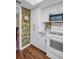 This kitchen features modern appliances, white cabinetry and unique wallpaper at 1001 Old Mill Pond Rd, Palm Harbor, FL 34683