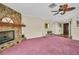 Cozy living room with a stone fireplace, wooden mantle, and a tropical ceiling fan at 1001 Old Mill Pond Rd, Palm Harbor, FL 34683