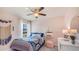 Cozy bedroom with soft pink walls, stylish furnishings, and natural light from the window at 30866 Wild Juniper Ct, Brooksville, FL 34602