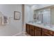 Bathroom with double vanity, wood cabinets, framed botanical print, and neutral color palette at 30872 Wild Juniper Ct, Brooksville, FL 34602