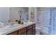 Bathroom with a dual sink vanity, framed botanical prints, a tub, and a shower at 30872 Wild Juniper Ct, Brooksville, FL 34602