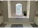Bathroom features a luxurious soaking tub with large window and tile surround at 9685 Southern Belle Dr, Weeki Wachee, FL 34613
