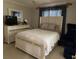 Bedroom features a large white bed, dresser, and a tufted chair at 9685 Southern Belle Dr, Weeki Wachee, FL 34613
