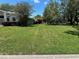 Exterior of the home featuring a well manicured lawn, mature landscaping, and neighboring homes at 9685 Southern Belle Dr, Weeki Wachee, FL 34613