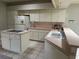 Bright eat-in kitchen featuring island with cooktop, white appliances, tile floors, and plenty of cabinet space at 9685 Southern Belle Dr, Weeki Wachee, FL 34613