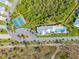 Aerial view of the community clubhouse, pool, tennis court, and lush landscaping at 10391 Coquina Ct, Placida, FL 33946