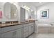 Bathroom with dual vanities, granite countertops, and a soaking tub at 10391 Coquina Ct, Placida, FL 33946