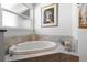 Bright bathroom featuring a soaking tub with marble surround and a framed window at 10391 Coquina Ct, Placida, FL 33946