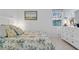 Bright bedroom with white furniture, floral bedding, and a large window at 10391 Coquina Ct, Placida, FL 33946