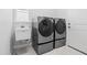 This laundry room features modern front load machines and a utility sink at 10391 Coquina Ct, Placida, FL 33946