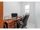 A home office features a wooden desk, ergonomic chair, and natural lighting at 10391 Coquina Ct, Placida, FL 33946