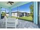 Covered patio with tile flooring, white modern chairs, and a screened-in view of the backyard at 10391 Coquina Ct, Placida, FL 33946