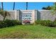 Stone monument at Coral Caye with lush green lawn and colorful flower arrangement at 10391 Coquina Ct, Placida, FL 33946