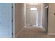 Bright hallway featuring neutral walls, carpet flooring, a white front door and interior doors at 13243 Gulf Bay Ln, Spring Hill, FL 34609