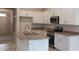 Modern kitchen with stainless steel appliances, light countertops and cabinets, and a kitchen island at 13243 Gulf Bay Ln, Spring Hill, FL 34609