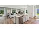 Kitchen and living room, wood-look floors, large windows, and white furniture with green and brown accents at 30860 Wild Juniper Ct, Brooksville, FL 34602