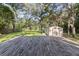 Large backyard with a shed, a deck, and mature trees at 8309 Oakgren Rd, Brooksville, FL 34601