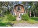 Quaint A-frame home with wood siding and a small front porch surrounded by lush greenery at 8309 Oakgren Rd, Brooksville, FL 34601