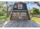 A-frame home with wood facade and large, inviting front deck, surrounded by trees at 8309 Oakgren Rd, Brooksville, FL 34601