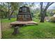 A-frame home with a spacious wooden deck, set in a lush, tree-filled yard for outdoor enjoyment at 8309 Oakgren Rd, Brooksville, FL 34601
