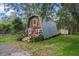 Charming A-frame home with a cozy front porch, complemented by an American flag and natural greenery at 8309 Oakgren Rd, Brooksville, FL 34601