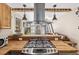 Well-appointed kitchen with stainless steel range hood, wood countertops, and modern appliances at 8309 Oakgren Rd, Brooksville, FL 34601