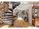 Spacious living room features spiral staircase, exposed beams, hardwood floors, and open kitchen layout at 8309 Oakgren Rd, Brooksville, FL 34601