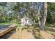 A simple backyard shed stands in a shady, tree-filled yard, offering practical storage at 8309 Oakgren Rd, Brooksville, FL 34601