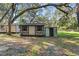 Simple backyard shed with an open storage area stands in a shady, tree-filled yard at 8309 Oakgren Rd, Brooksville, FL 34601