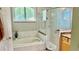 Bright bathroom featuring a soaking tub, glass shower, granite counters, and shuttered window at 1138 Lumsden Trace Cir, Valrico, FL 33594